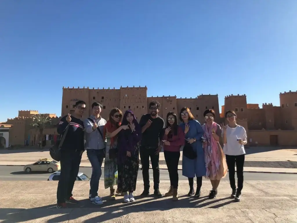 Viajantes junto à muralha de uma antiga kasbah nas nossas viagens privativas no Marrocos