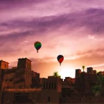 Hot air balloons over a kasbah with Traveling Morocco