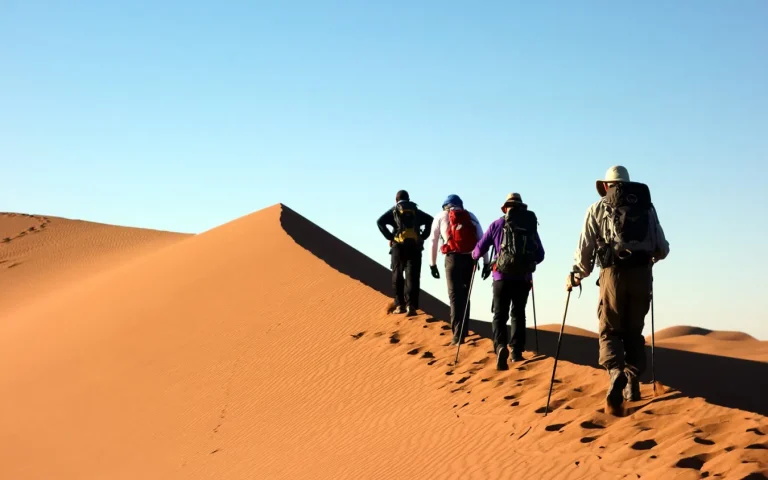 Caminhantes a subir uma duna do Saara – Viagem de 12 dias no Marrocos a partir de Casablanca