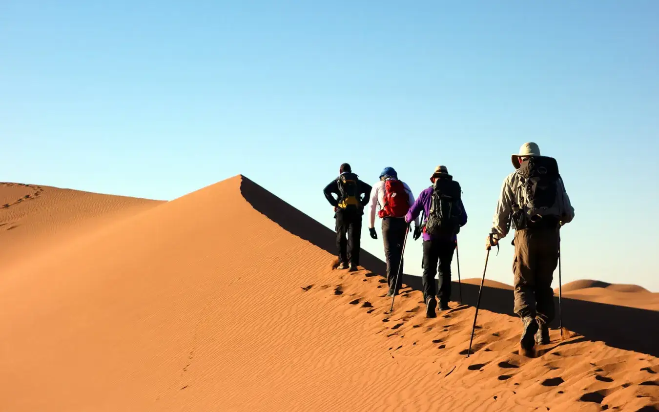 Escursionisti che salgono su una duna del Sahara – Tour nel Deserto di 3 Giorni da Fes a Marrakech