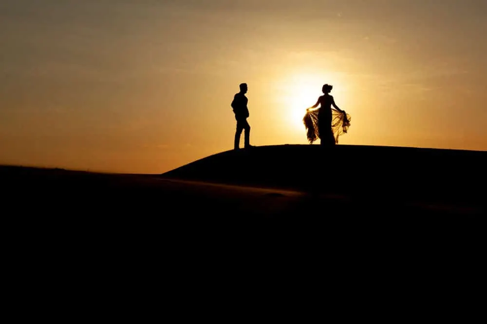 Silhuetas de viajantes numa duna ao pôr do sol – Viagem de 3 dias ao deserto de Errachidia a Merzouga
