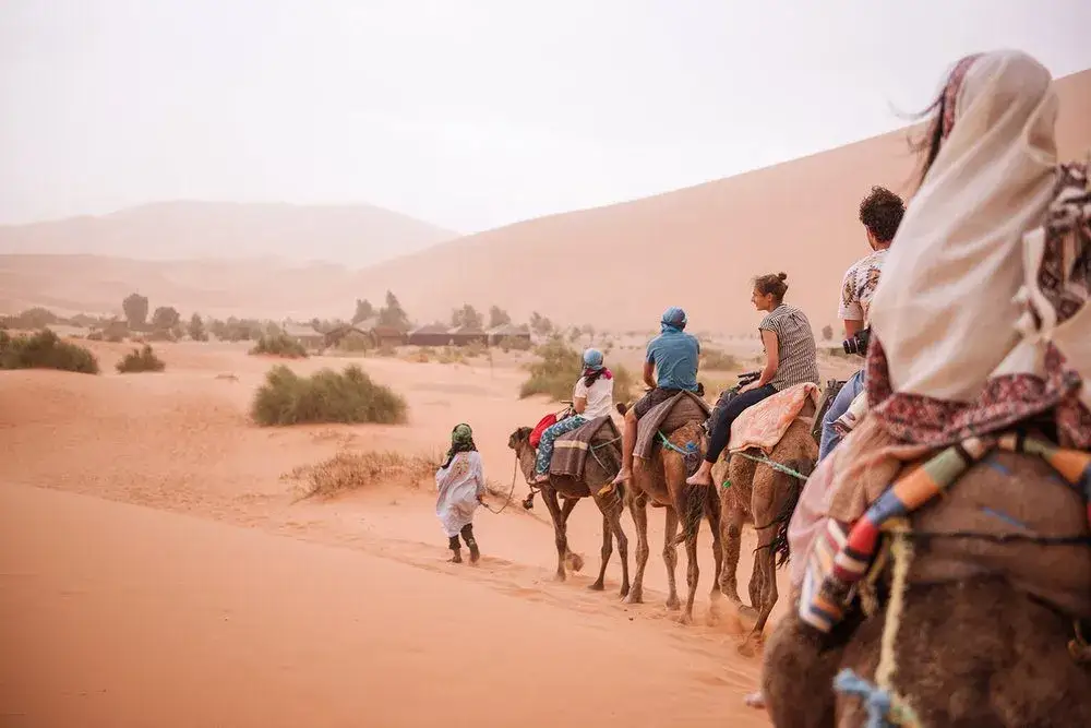 Cavaleiros de camelo na luz pastel das dunas – Excursão de 6 Dias ao Deserto a Partir de Marraquexe