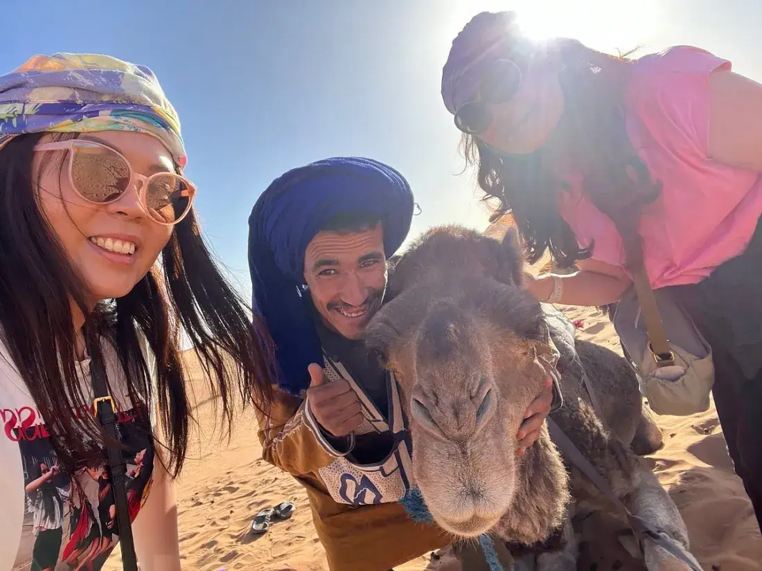 Viajantes a tirar uma selfie com um camelo e um guia berbere – Viagem de 7 Dias ao Marrocos a Partir de Fez